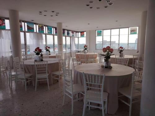 a room with tables and chairs with flowers on them at Hotel la fortuna in Tuxpan de Rodríguez Cano