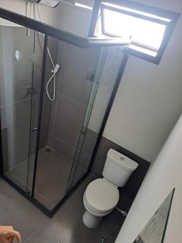 a bathroom with a toilet and a shower at Apartamento casa da Lu 102 in Primavera do Leste