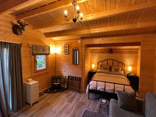 a bedroom with a bed in a wooden cabin at Glenhill Lodge in Roybridge