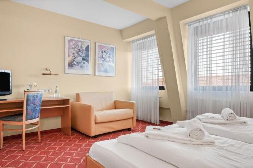 a hotel room with two beds and a desk and a chair at XZLLENZ light, Parken, 24h digitaler Check In und Zugang in Oberasbach
