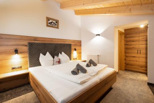 a bedroom with a large bed with white sheets at Schönachhof in Gerlos