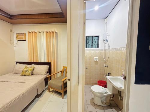 a bedroom with a bed and a sink and a toilet at Sim's Agan South Villas in Lagao III