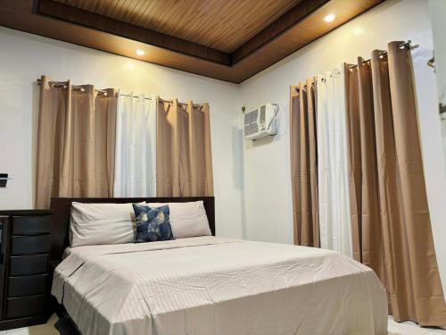 a bedroom with a bed and curtains in it at Sim's Agan South Villas in Lagao III