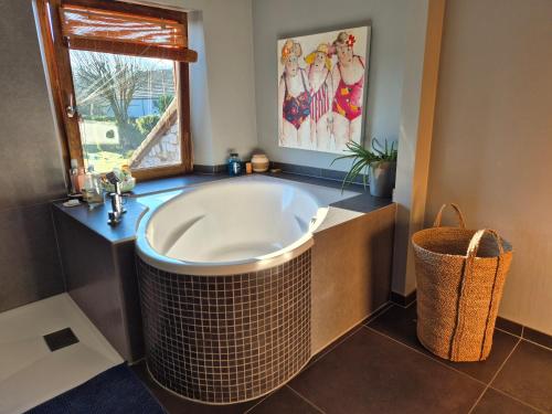 a bathroom with a large tub and a window at Chambre de Arnaud à Gerpinnes in Gerpinnes