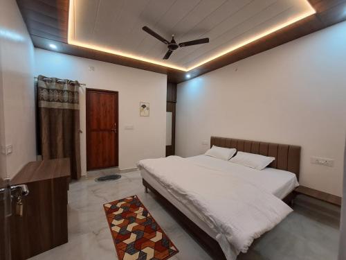 a bedroom with a bed and a ceiling fan at MG Stay AYODHYA in Faizābād