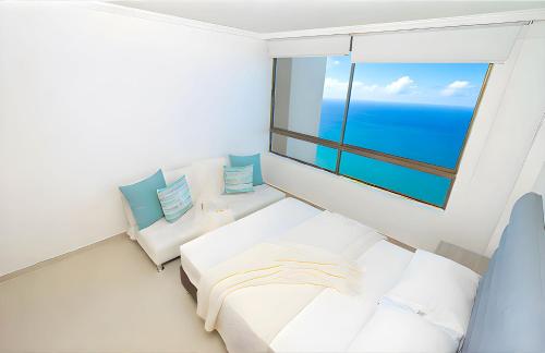 a bedroom with a bed and a large window at Peñón del Rodadero Apartments – Oceanfront by SOHO in Rodadero