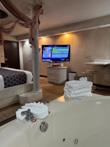 a hotel room with a bed and a flat screen tv at Blue Star Motel in Chicago Ridge
