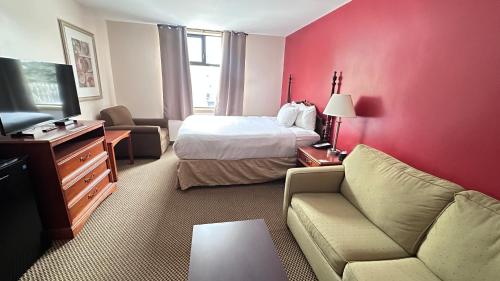 a hotel room with a bed and a couch and a tv at Econo Lodge City Centre in Kingston