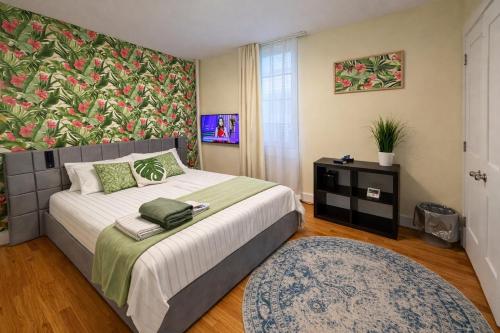 a bedroom with a large bed with a floral wall at Tropical style room in Geusthouse in New York