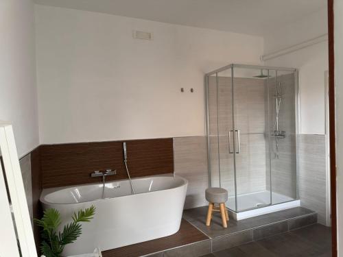 a bathroom with a tub and a glass shower at 1402 Rooms in Matera