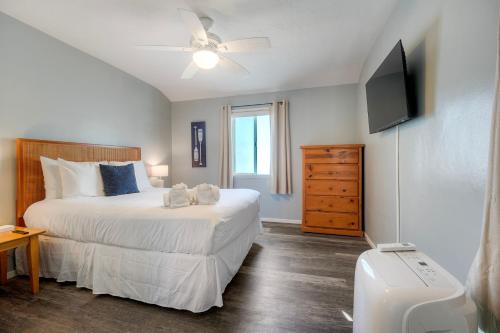 a bedroom with a large bed and a television at Oceanfront Condo, Private Balcony, Beach Access, Sunset Views in Carlsbad