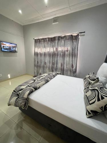a bedroom with a bed with a curtain and a window at Davidson Lodge in Goodwood