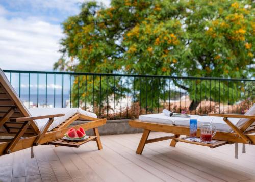 a balcony with a bed and chairs on a deck at Madeira Precious Family Apartment in Funchal