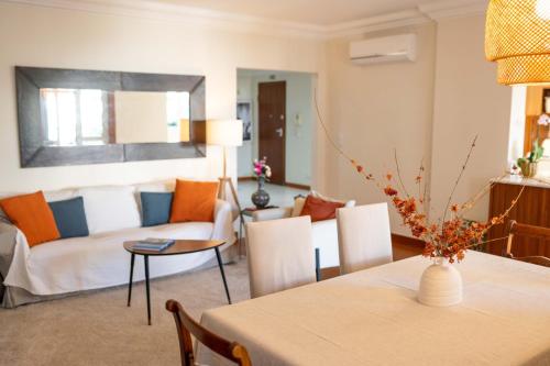 a living room with a table and a couch at Madeira Precious Family Apartment in Funchal
