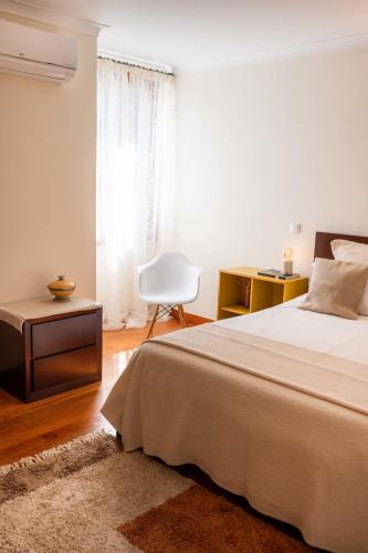 a bedroom with a bed and a desk and a chair at Madeira Precious Family Apartment in Funchal