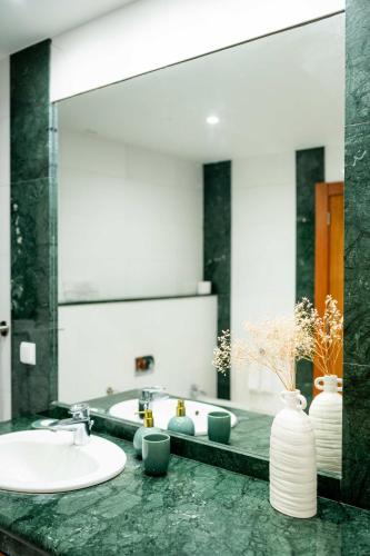 a bathroom with a sink and a large mirror at Madeira Precious Family Apartment in Funchal