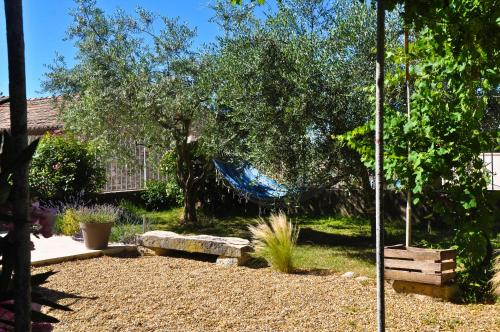 a garden with a blue hammock hanging from a tree at Maison d'hôtes Le Jas Vieux in Montfort