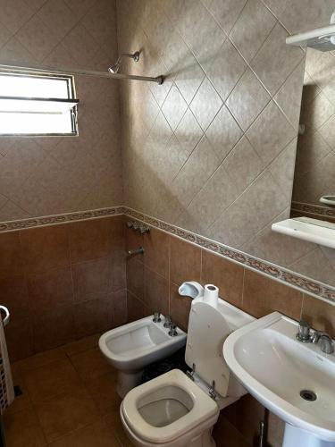 a bathroom with a toilet and a sink at Complejo Esterlicia in Santa Rosa