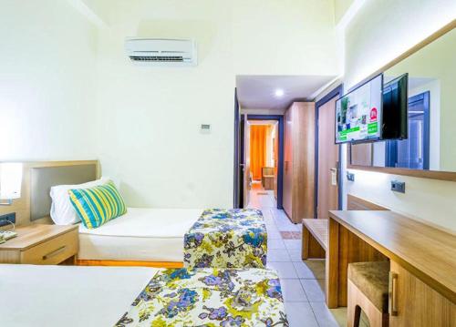 a hotel room with a bed and a tv at ESMA CLOVE RESORT&SPa in Eskiömerler