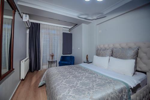 a bedroom with a large bed and a blue chair at White Moon Suites in Istanbul