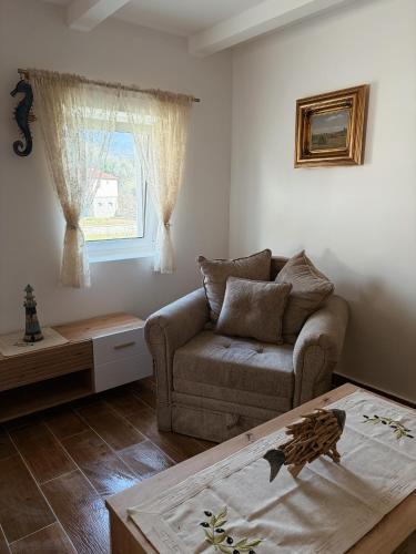 a living room with a couch and a table at Sasovici farmstay in Magazini