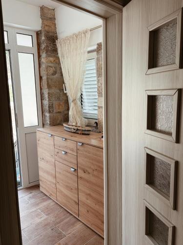 a dressing room with a mirror and a wooden dresser at Sasovici farmstay in Magazini
