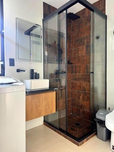 a bathroom with a glass shower and a sink at Urban Escape Sky View in Cochabamba