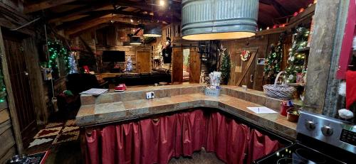 a kitchen with a large counter with a red curtain at Rural life on a real Christmas tree farm! Hallmark experience! in Ozark