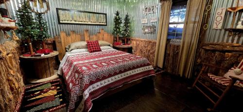 a bedroom with a bed in a room with christmas trees at Rural life on a real Christmas tree farm! Hallmark experience! in Ozark