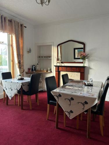 a dining room with a table and chairs and a mirror at Tay Villa in Inverness