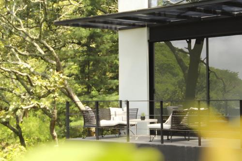 a group of chairs and a table on a patio at Loft hermoso entre el bosque, vista al Lago. in Valle de Bravo
