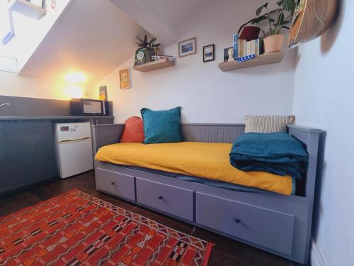 a bedroom with a bed with yellow sheets and blue pillows at Studio côté Canal Hossegor in Hossegor