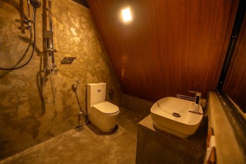 a bathroom with a toilet and a shower and a sink at Green Infinity Resort in Diyatalawa