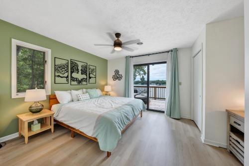 a bedroom with green walls and a bed and a window at Sundance - Lakefront w/ Private Dock in Moneta