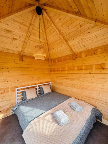 a bedroom with a bed in a wooden cabin at The Bee Garden - Cosy Cabin in Lede