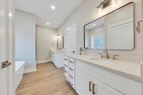 a white bathroom with a sink and a large mirror at Lake Twin Cove - New! in Moneta