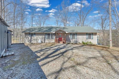 a house with a red door on a gravel driveway at Whisper Haven - Private dock & Pet friendly in Moneta