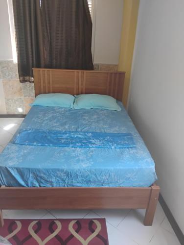 a bed in a room with a blue comforter at Flat Bonito e Confortável in Campos dos Goytacazes