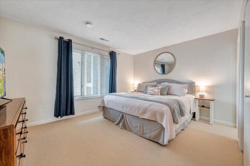a white bedroom with a bed and a mirror at Lake Vibes - Pet Friendly Lakefront Condo! in Moneta