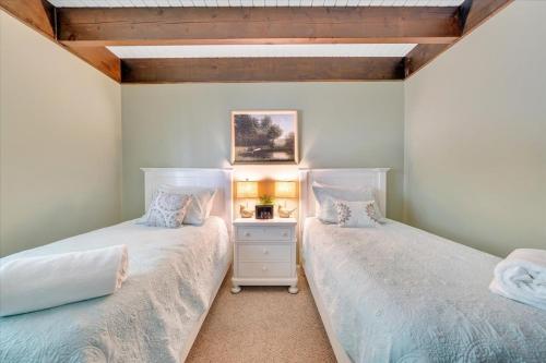 two beds sitting next to each other in a bedroom at Summer Breeze - Lakefront w/ Private Dock! in Moneta