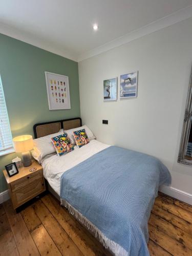 a bedroom with a bed and a night stand with a lamp at Ocean Reach in Porthcawl