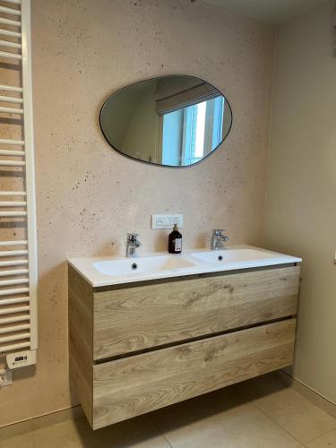 a bathroom with a sink and a mirror at Noordzeehuys in Middelkerke
