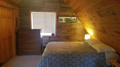 a bedroom with a bed and a window at Chalet Cabin 7-Acres Pond! in Andover