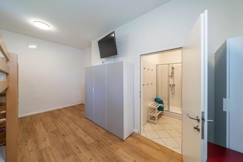 a room with a white refrigerator and a bathroom at Ferienwohnungen Hebalm in Pack