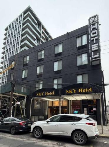 a white car parked in front of a sky hotel at Sky Hotel Flushing/Laguardia Airport in Queens