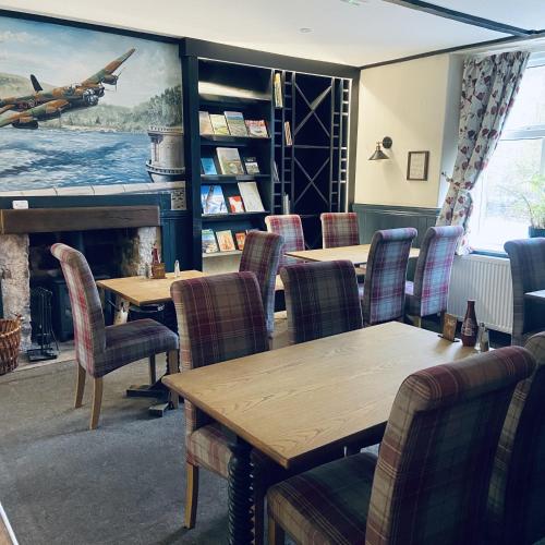 a restaurant with tables and chairs and a fireplace at The Ladybower Inn in Bamford