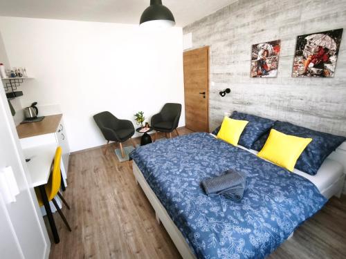 a bedroom with a bed with blue and yellow pillows at Vila Olivín - Private rooms with bathroom in Banská Bystrica