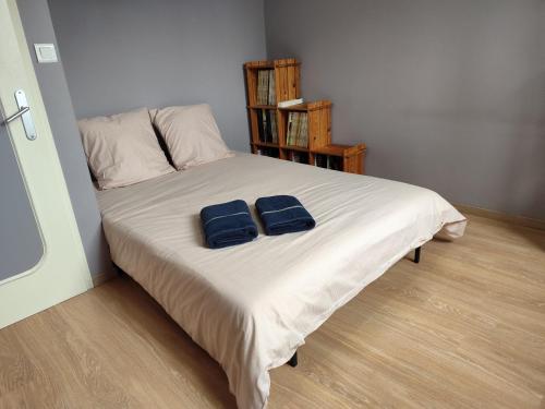 two blue towels sitting on a bed in a bedroom at Maison 3 chambres Le Mans, proche circuit in Le Mans