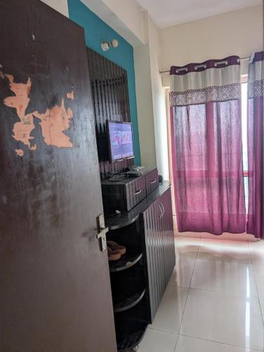 a room with a door and a tv in a room at Panchsheel Greens 2 in Ghaziabad