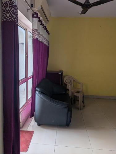 a living room with a chair and a window at Panchsheel Greens 2 in Ghaziabad